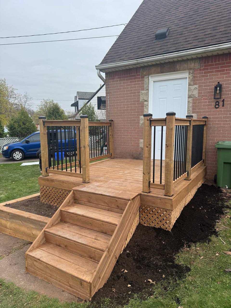 Pressure-treated front porch with black spindles